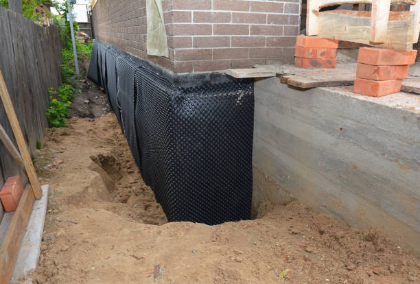 SJ Waterproofing Pros technician performing targeted Wet Basement Repair assessment in Greenville, IL